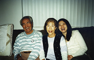 Emi Gusukuma and her parents Gus and Yuki sitting on the couch