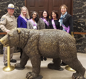 Long distance caregiver Emi Gusukuma and advocates in front of the California Bear at the State Capitol in Sacramento