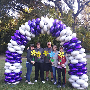 Laura McDermott living with Alzheimer's holds a blue flower