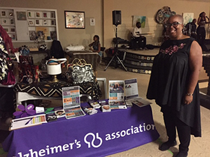 Teri Carlyle poses next to her Alzheimer's Association table at The Longest Day fundraising event 