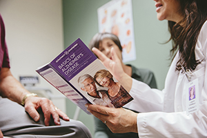 Doctor shares Alzheimer's Association's Basics of Alzheimer's Disease brochure with patient and their caregivers