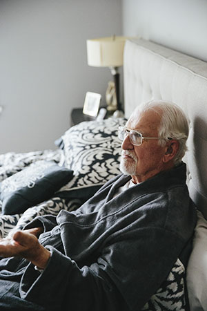 MAN SITTING IN BED