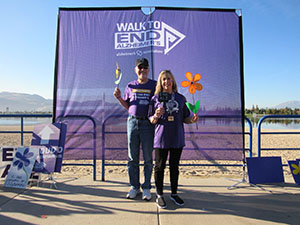 Nancy and husband hold flowers at Reno-Sparks Walk to End Alzheimer's in honor of her mother