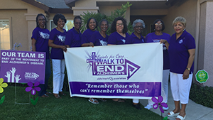 Saints for the Cure a Walk to End Alzheimer's team pose with their sign