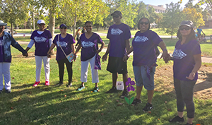 Saints for a Cure team holds hands under the oak tree during the Walk to End Alzheimer's