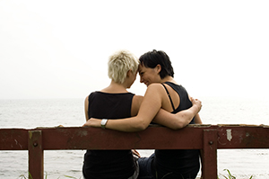 LGBTQ couple sits alone on a bench