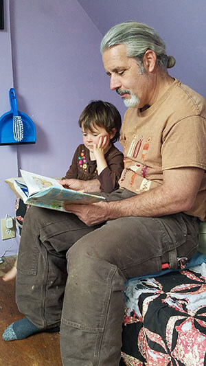 Bud who is living with Alzheimer's reads with his grandchild 