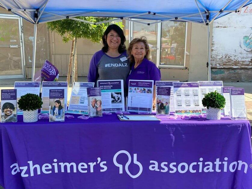 Hortencia and Alzheimer's Association staff member staffing resource table at community event