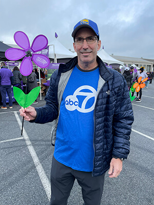 Todd holds a purple flower at the Walk to End Alzheimer's in San Francisco 